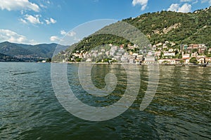 Como, ITALY - August 4, 2019: Apartments, villas, hotels on the green forested mountainsides near Lake Como. Beautiful Italian