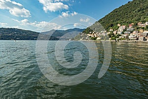 Como, ITALY - August 4, 2019: Apartments, villas, hotels on the green forested mountainsides near Lake Como. Beautiful Italian