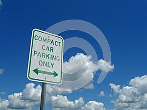 Compact Car Parking Only Sign with blue sky and clouds