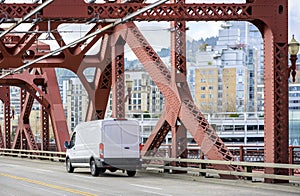 Compact cargo white mini van running on the Broadway Bridge in Portland