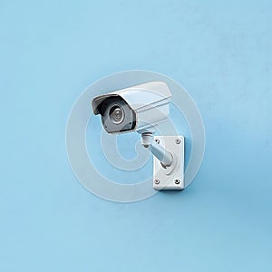 Compact CCTV security camera mounted on light blue background wall