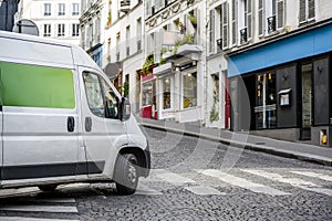 Compact economical mini van for small business and local delivery turning on crossroad on the city street photo