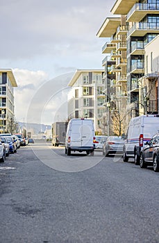 Compact different cargo delivery mini vans standing on the urban city street unloading goods