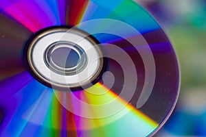 Compact Disc. Holding a CD in hands. The back side of the CD reflects colorful lights. Rainbow colors