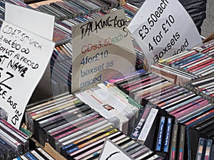 Close up of a stack of various compact discs, cds for sale on a stall