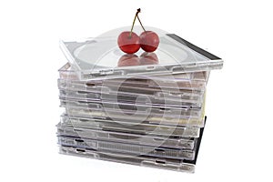 Compact discs in packs with two cherries on top, close-up