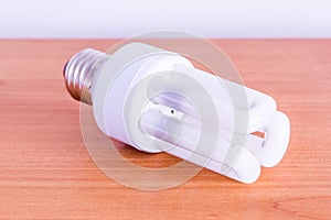 Compact fluorescent lamp on wooden table