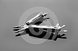 Compact portable metallic multitool on grey table