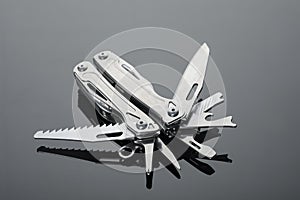 Compact portable metallic multitool on table, closeup