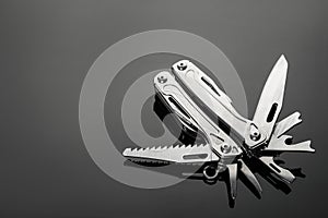 Compact portable metallic multitool on table, space for text
