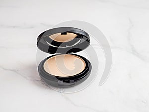 Compact powder on white marble, copy space