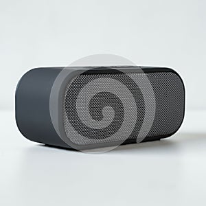 A compact, rectangular Bluetooth speaker with rounded edges. It features a mesh