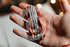 A compact red multitool resting in an open hand, showcasing its metal bits and practical design. Perfect for