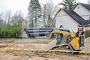 Compact Track Loader Hauling Corrugated Drainage Pipes