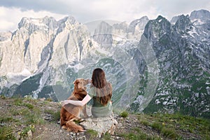 Companionable moment in the mountains. A woman and her loyal dog sit together
