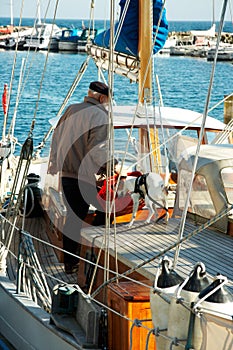 Companions getting ready for another journey. An elderly man and his dog standing in a cluttered boat.