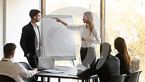 Company boss and business trainer make presentation during group meeting