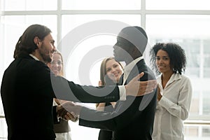 Company boss promoting african american employee with handshake