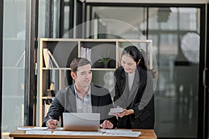 Company CEO and Top Manager Talking, Using Laptop Computer in office. Two Successful Professional People Brainstorm