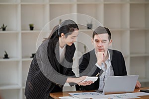 Company CEO and Top Manager Talking, Using Laptop Computer in office. Two Successful Professional People Brainstorm