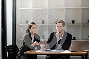 Company CEO and Top Manager Talking, Using Laptop Computer in office. Two Successful Professional People Brainstorm