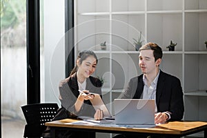 Company CEO and Top Manager Talking, Using Laptop Computer in office. Two Successful Professional People Brainstorm