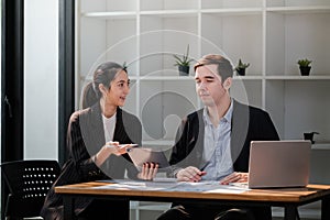 Company CEO and Top Manager Talking, Using Laptop Computer in office. Two Successful Professional People Brainstorm