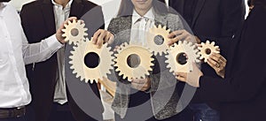 Company employees joining gearwheels as metaphor for effective business management and teamwork