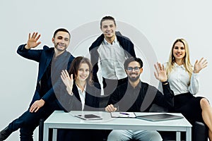 Company employees sitting at conference table in office having online meeting