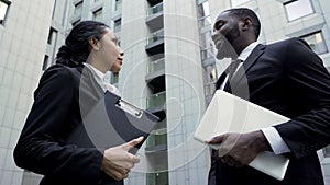 Company employees talking near office building, successful teamwork on project