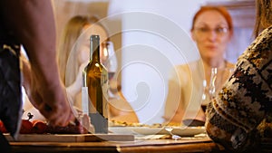 A company of friends is sitting by the table and having a feast