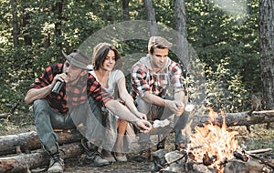 Company having hike picnic nature background. Weekend. Happy young people camping in woods. Hikers sharing impression of