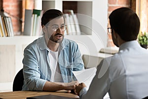 Company HR manager interviewing young male applicant at job interview