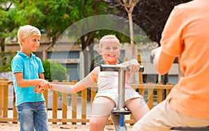 Company of kids are teetering on the swing photo