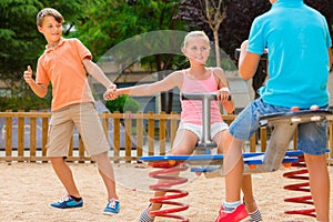 Company of kids are teetering on the swing photo