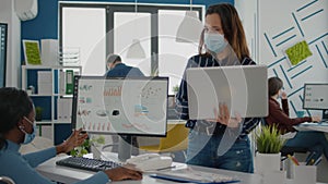 Company manager with mask explaining to paralysed african colleague project plan