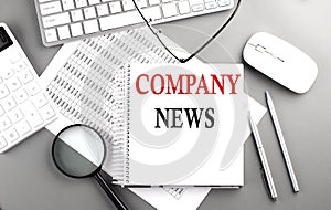 COMPANY NEWS text on notepad on chart with keyboard and calculator on grey background