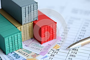 Company shipping cargo containers in India with rupees money bills and pen