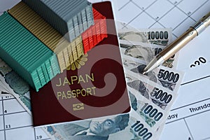 Company shipping cargo containers in Japan with yen money bills and pen