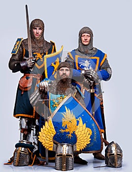 Company of three knights with helmets on a ground