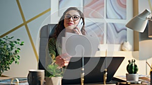 Company worker speaking mobile phone at office table closeup. Employee calling