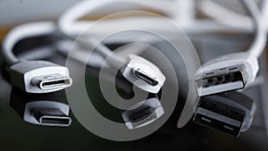 Comparison of three types of male USB connectors. USB Type-C, Micro USB and Type-A. Dark reflective background. Macro. Selective