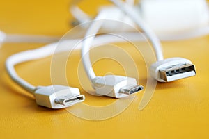 Comparison of three types of USB connectors. USB Type-A, Micro USB and Type-C. Yellow background. Macro. Selective focusing. Free