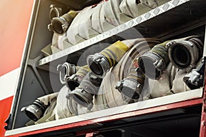 Compartment of rolled up fire hoses on a fireengine. Emergency s
