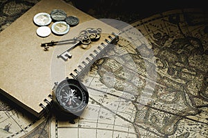 Compass, antique keys and notebook on blur vintage world map, journey concept, copy space