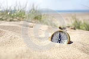 Compass on the beach with sand and sea