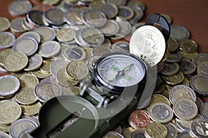 Compass and Bitcoin on a pile of Euro coins photo