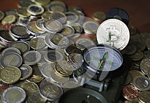 Compass and Bitcoin on a pile of Euro coins photo