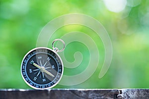 Compass with blur green background, journey planning concept