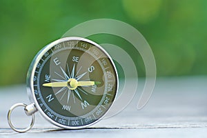 Compass with blur green background, journey planning concept